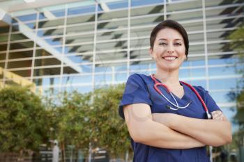 Smiling Hispanic female healthcare worker outdoors, portrait