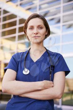 Smiling white female healthcare worker outdoors, vertical