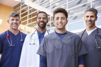 Four male healthcare colleagues standing outdoors, portrait
