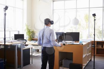 Businessman using VR technology in an office, back view