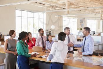 Businessman addressing team at a meeting in open plan office