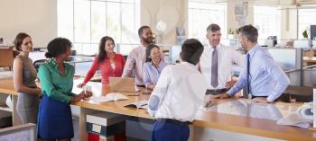 Businessman addressing team in open plan office, panoramic