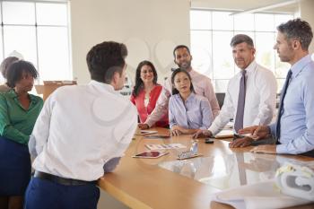 Business team stand at a meeting around a table in an office