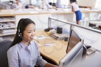 Smiling Asian woman working in a call centre, elevated view