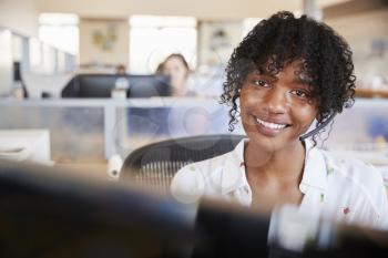 Young black woman working in a call centre smiling to camera