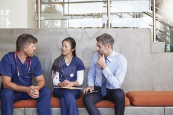 Healthcare workers talk sitting on a bench in hospital