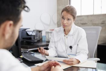 Concerned female doctor in consultation with male patient