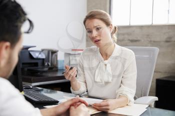 Concerned female therapist in consultation with male patient