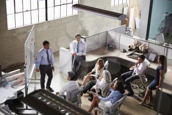 Businessman giving presentation to colleagues, elevated view