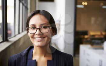 Young mixed race businesswoman wearing glasses, close up
