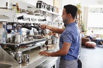 Young male barista preparing espresso at a coffee shop