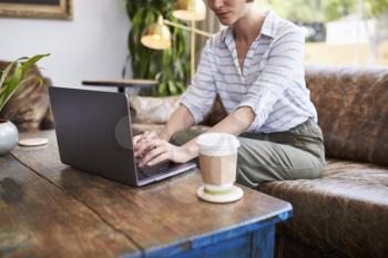 Young woman using laptop sitting in a coffee shop