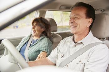 Senior mixed race couple sit smiling in car