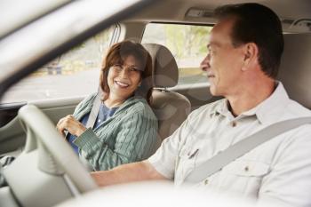 Senior mixed race couple in car going on holiday