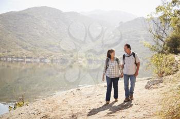 Senior couple hiking by a mountain lake
