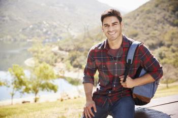 Young Hispanic man smiling during mountain hike, portrait