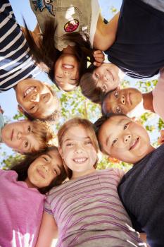 Group of kids outdoors looking down at camera,verticle