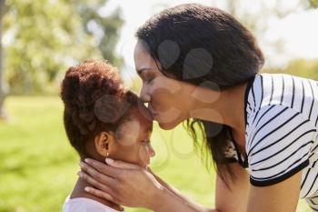 Close Up Of Mother Kissing Daughter In Park