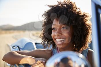 Portrait Of Woman Enjoying Road Trip In Open Top Classic Car