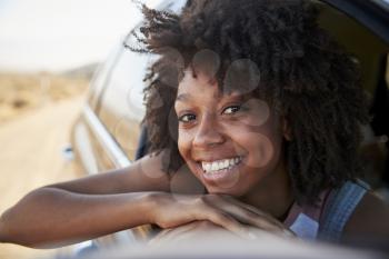 Portrait Of Smiling Woman Looking Out Of Car Window Enjoying Road Trip