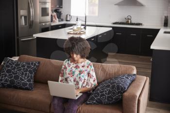 Elevated View Of Woman Sitting On Sofa At Home Using Laptop