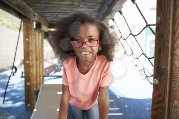 Young black girl in school playground, looking to camera