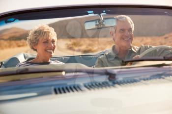 Senior couple on a US road trip, seen through car windscreen