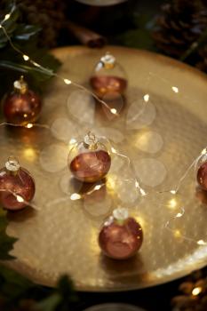 Close up of Christmas baubles on a gold table with warm glow, selective focus