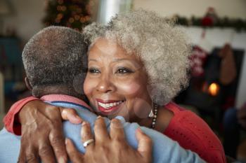 Senior Couple Hugging As They Celebrate Christmas At Home Together