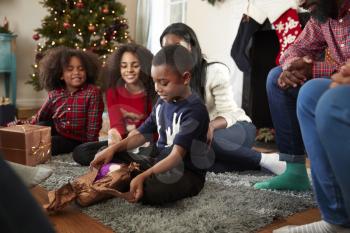Son Opening Gift As Multi Generation Family Celebrate Christmas At Home Together