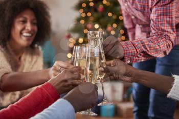 Close Up Of Friends Making A Toast With Champagne As They Celebrate Christmas At Home Together