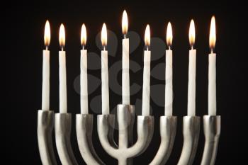 Lit Candles On Metal Hanukkah Menorah Against Black Studio Background