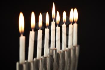 Close Up Of Lit Candles On Metal Hanukkah Menorah Against Black Studio Background