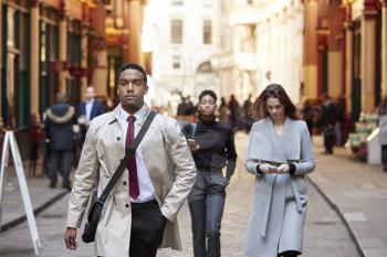 Millennial business people walking in a London street, front view