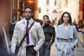 Millennial business people walking in a London street, front view, close up