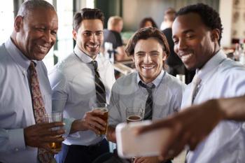 Group Of Businessmen Taking Selfie In Bar At After Work Drinks In Bar