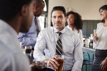 Two Businessmen Meeting For After Works Drinks In Bar