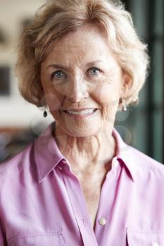 Portrait Of Smiling Senior Woman Sitting In Restaurant