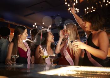 Group Of Female Friends Celebrating With Bride On Hen Party In Bar