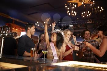 Group Of Dancing Friends Celebrating With Bride On Hen Party In Bar