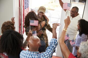 Young black soldier returning home to a surprise family party, close up