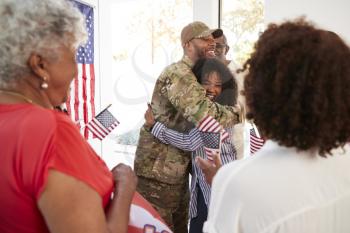 Millennial black soldier embracing his family after returning home,close up, selective focus