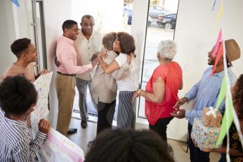 Black family members embracing at a surprise party, elevated view