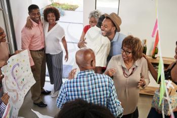 Black family members embracing at a surprise party, elevated view