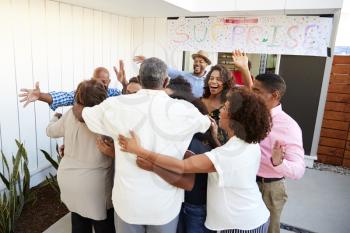 Three generation black family welcoming grandparents to a surprise party