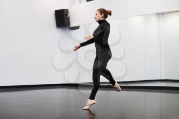 Female Student At Performing Arts School Rehearsing Ballet In Dance Studio