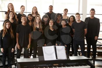 Portrait Of Male And Female Students Singing In Choir With Teacher At Performing Arts School