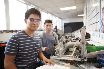 Portrait Of Two Male College Students Building Machine In Science Robotics Or Engineering Class