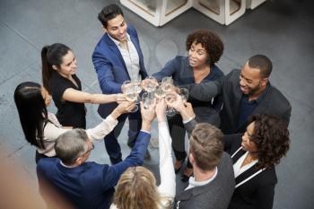 Overhead Shot Of Business Team Celebrating Success With Champagne Toast In Modern Office
