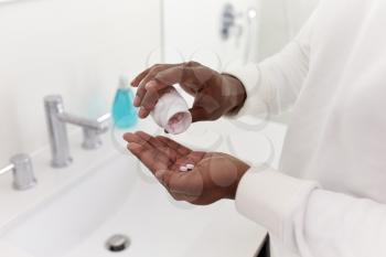 Close Up Of Man In Bathroom Taking Vitamin Supplement Tablets